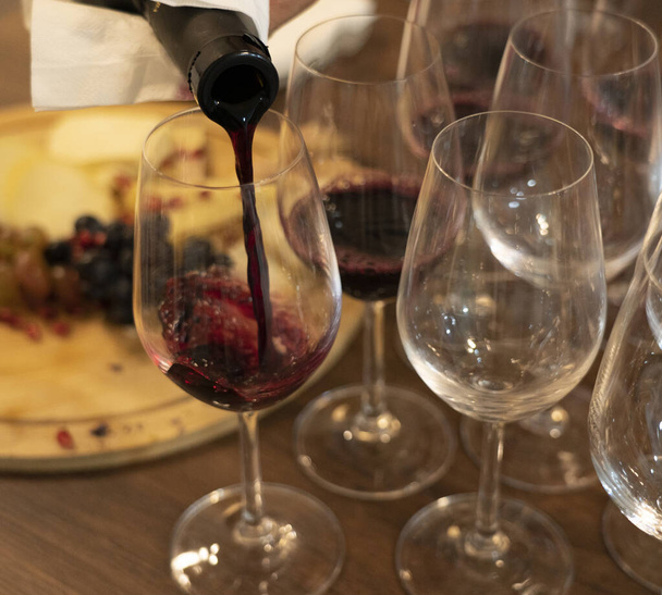 ワインはボトルからグラスに注がれる - 写真・画像