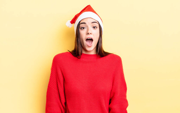 young hispanic woman looking very shocked or surprised. chistmas and new year concept - Zdjęcie, obraz