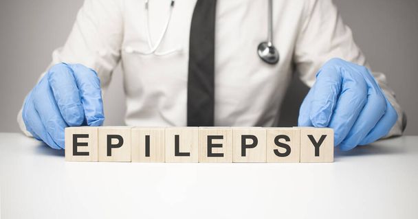Doctor holds wooden cubes in his hands with text epilepsy - 写真・画像