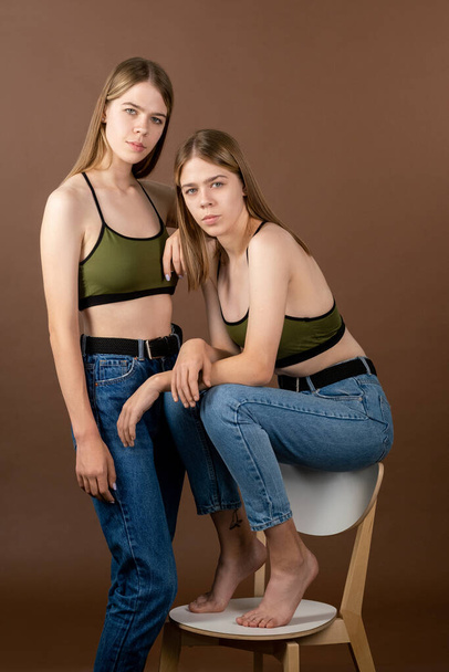 二つのかなり十代の女の子でタンクトップとブルージーンズ - 写真・画像