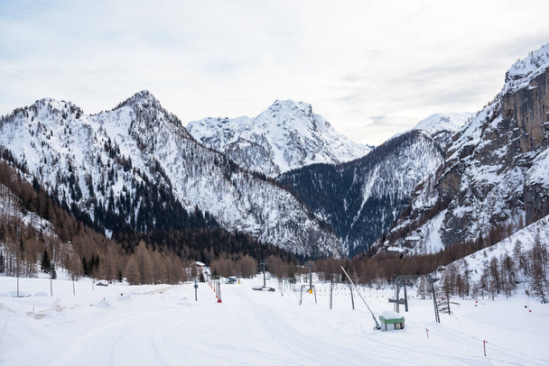 Bulutlu bir günde önplanda boş kayak pistleri olan kış manzarası - Fotoğraf, Görsel