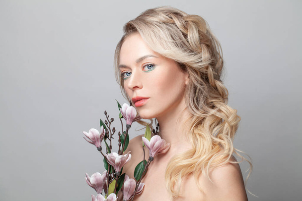 Perfect woman holding flowers. Pretty spa model with clean fresh skin. Cosmetology, beauty and Spa - Fotó, kép