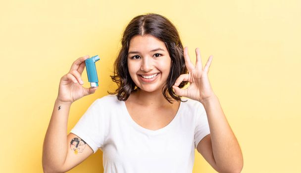 young hispanic woman feeling happy, showing approval with okay gesture. asthma concept - Fotoğraf, Görsel