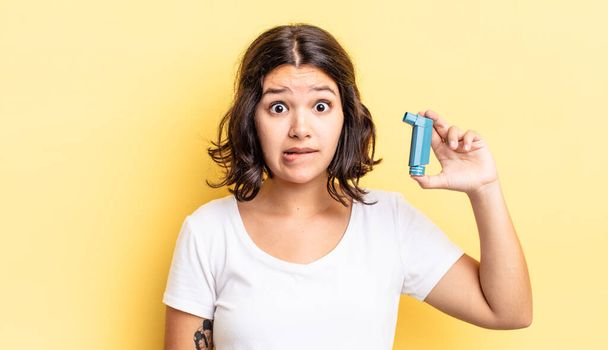 young hispanic woman looking puzzled and confused. asthma concept - 写真・画像