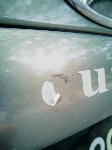 Old sticker on the car. Remove the adhesive letter from the car body. - Photo, Image