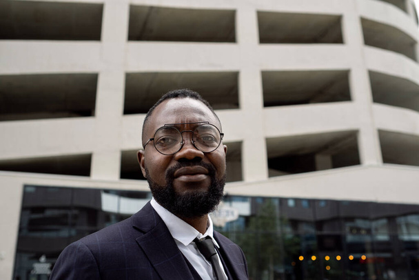 Mladý africký bankéř v brýlích stojící před kamerou - Fotografie, Obrázek