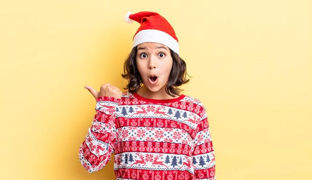 young hispanic woman looking astonished in disbelief. christmas concept - Zdjęcie, obraz