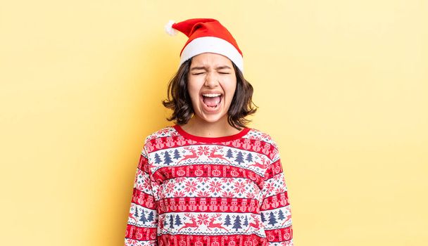 young hispanic woman shouting aggressively, looking very angry. christmas concept - Foto, immagini