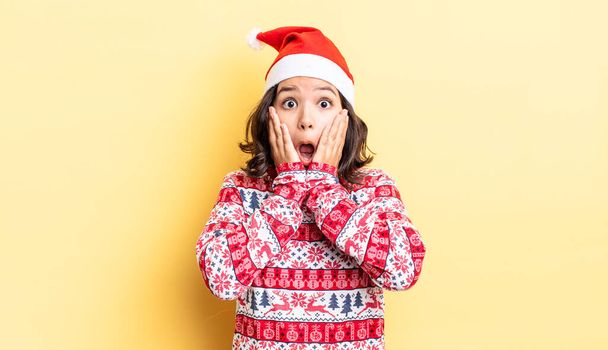 young hispanic woman feeling shocked and scared. christmas concept - Fotoğraf, Görsel