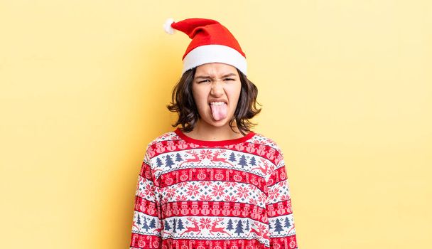 young hispanic woman feeling disgusted and irritated and tongue out. christmas concept - Fotoğraf, Görsel
