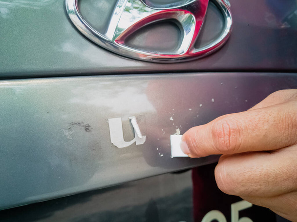 Удалите клей буквы из кузова автомобиля. - Фото, изображение