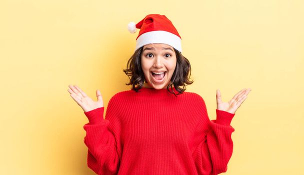 young hispanic woman feeling happy and astonished at something unbelievable. christmas concept - Photo, image