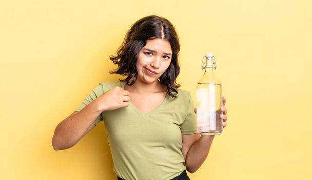 young hispanic woman looking arrogant, successful, positive and proud. water bottle concept - Foto, Bild