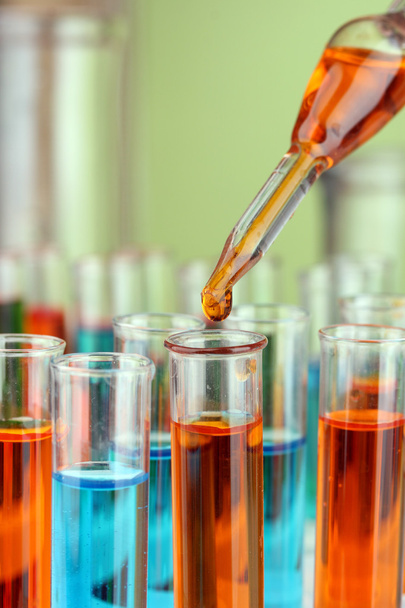 Pipette de laboratoire avec goutte de liquide de couleur sur éprouvettes en verre, gros plan
 - Photo, image