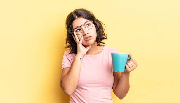 young hispanic woman feeling bored, frustrated and sleepy after a tiresome. coffee mug concept - Photo, Image