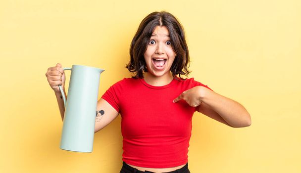 young hispanic woman feeling happy and pointing to self with an excited. thermos concept - Фото, изображение