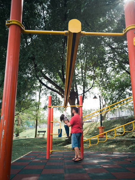Asian Father and kids playing on monkey bars at the park. - Photo, Image