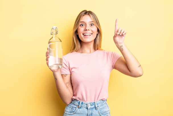 pretty blonde girl feeling like a happy and excited genius after realizing an idea. water bottle concept - Fotoğraf, Görsel