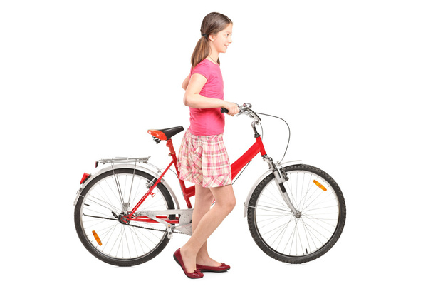 Young girl pushing bike - Фото, изображение