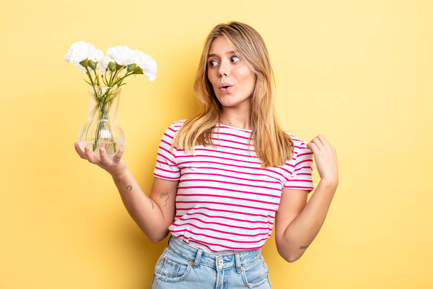 pretty blonde girl feeling stressed, anxious, tired and frustrated. decorative flowers concept - 写真・画像