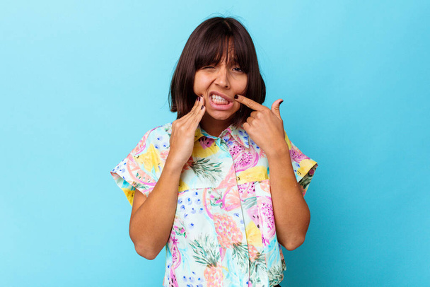 Young mixed race woman isolated on blue background having a strong teeth pain, molar ache. - Photo, Image