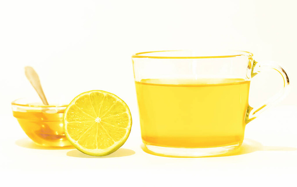yellow tea with honey and lemon on a white background - Foto, imagen