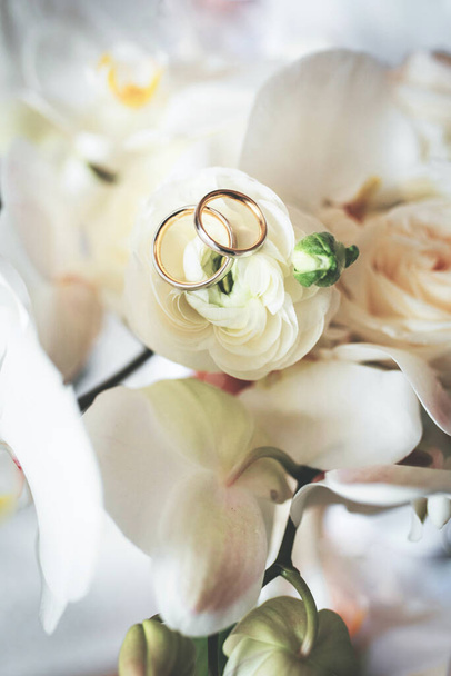 wedding rings on a bouquet of flowers - Foto, imagen