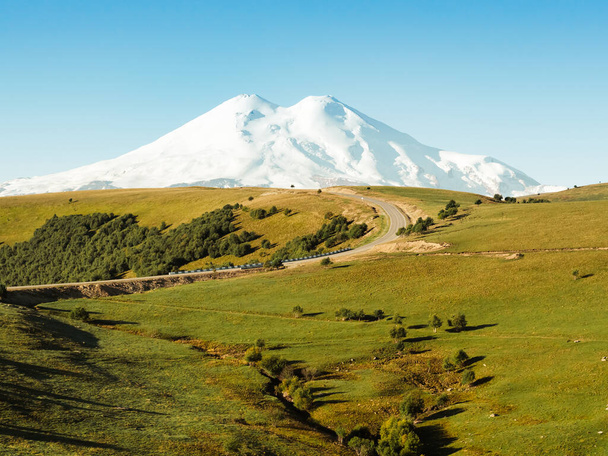 Uma bela curva da estrada através das colinas verdes do Cáucaso para Elbrus. - Foto, Imagem
