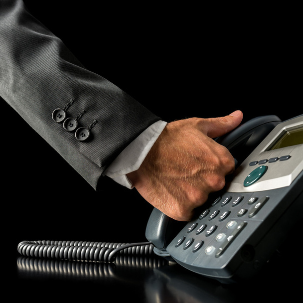 Hand of a businessman picking up the receiver - Photo, Image