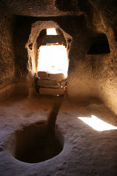 jeskynní domy a kostely vytesané do sopečných skal s dveřmi a okny a vnitřními komorami - Fotografie, Obrázek