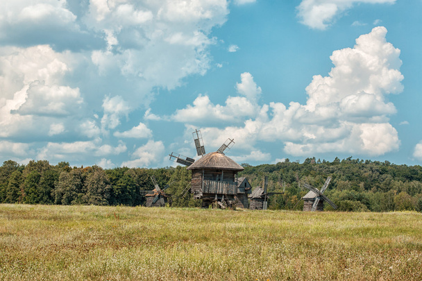 Old wooden windmills on the field. - Zdjęcie, obraz
