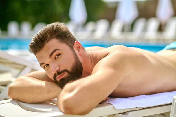 A dark-haired man sunbathing and looking relaxed - Valokuva, kuva