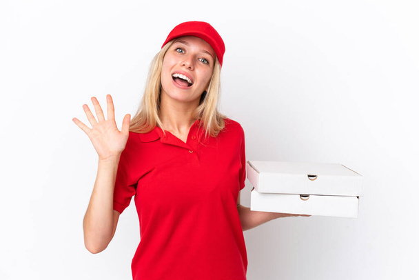 Házhozszállítás nő gazdaság pizza elszigetelt fehér háttér szalutál kézzel boldog arckifejezéssel - Fotó, kép
