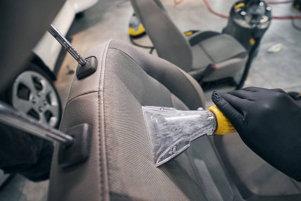 Nettoyage sous vide et séchage du siège en cuir par un technicien d'entretien automobile - Photo, image