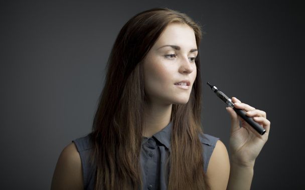 Elegant, beautiful woman smoking e-cigarette - Foto, Imagem