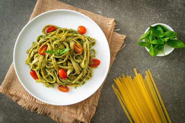 fettuccine spaghetti pasta with pesto sauce and tomatoes - vegan and vegetarian food style - Foto, Imagem