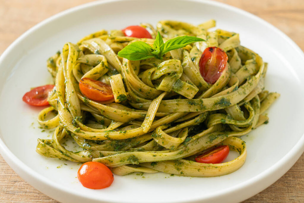 fettuccine spaghetti pasta with pesto sauce and tomatoes - vegan and vegetarian food style - Foto, Imagem
