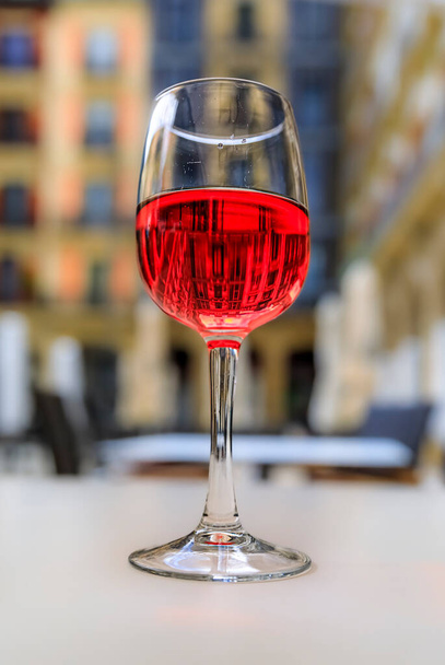 Glass of Spanish rose or rosado in a restaurant on a square in Pamplona, Spain - Fotó, kép
