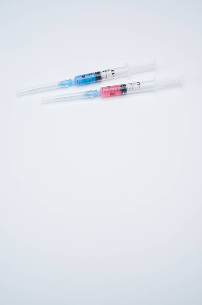 Two syringes on a blue background with copy space - Zdjęcie, obraz