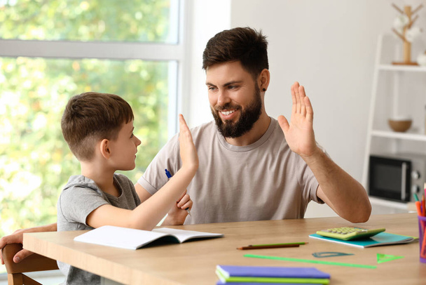 Little boy with his father giving each other high-five at home - Photo, Image
