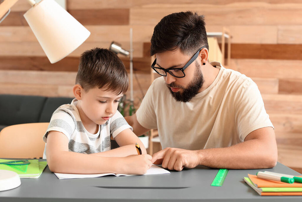 Kleiner Junge mit seinem Vater beim Unterricht zu Hause - Foto, Bild