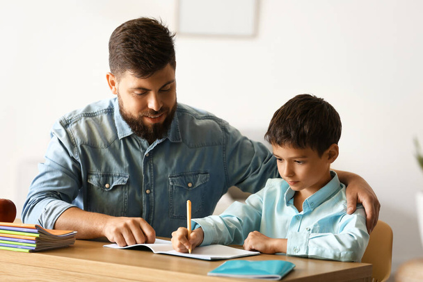 Niño pequeño con su padre haciendo clases en casa - Foto, imagen