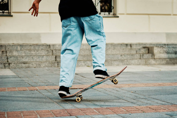 Skateboarder ride on skateboard at city street, close up - Photo, Image