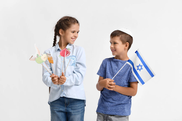 Little children with flag of Israel and decor for Rosh Hashanah (Jewish New Year) on white background - Photo, image