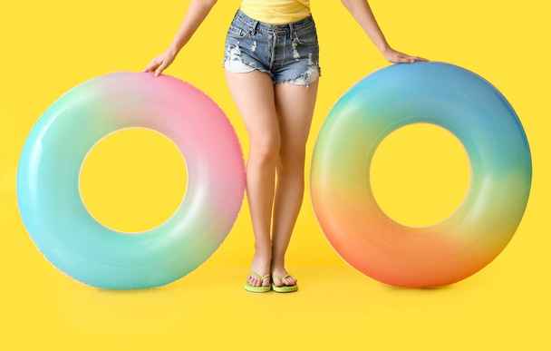 Giovane donna con anelli gonfiabili su sfondo di colore - Foto, immagini