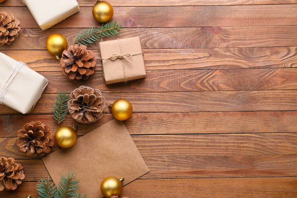 Weihnachtsgeschenke mit Tannenzapfen und Kugeln auf Holzgrund - Foto, Bild