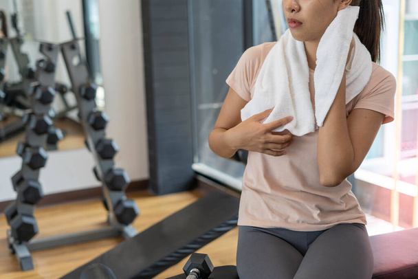 A nők edzés után szünetet tartanak egy fitnesz teremben. A nők stresszmentesnek érzik magukat a súlyzókkal való sportolás után.. - Fotó, kép