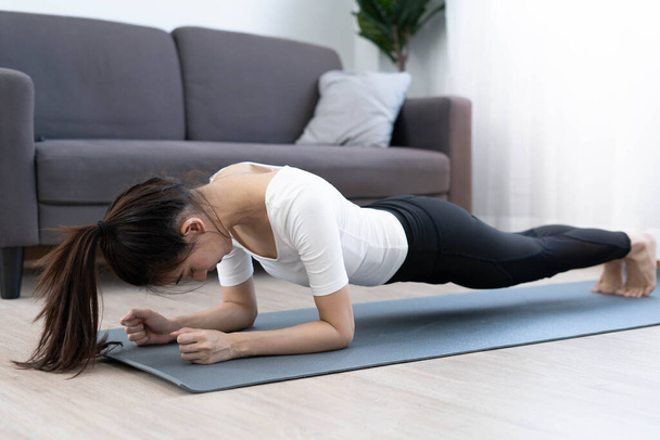 Las mujeres asiáticas hacen ejercicio en casa en la sala de estar. Las mujeres de cuidado de la salud hacen Plank a dieta. - Foto, Imagen