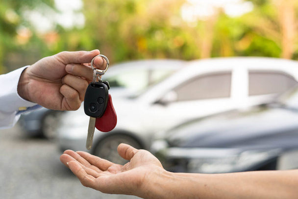 vente de voiture, vente de voiture, concept d'affaire Le concessionnaire donne les clés de la voiture au nouveau propriétaire ou locataire avec un contrat d'assurance. - Photo, image