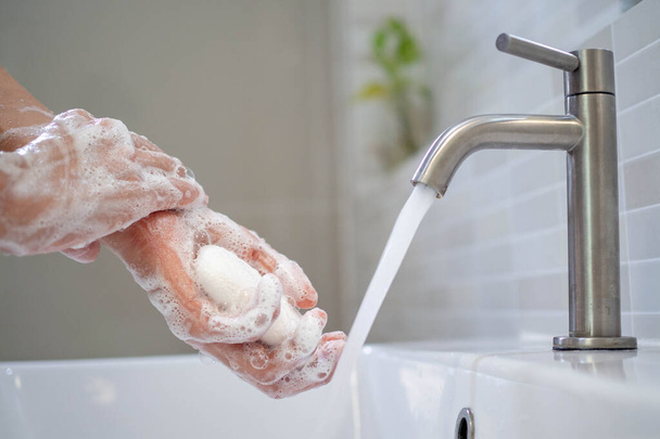 Persönliche Hände mit Seifenblasen waschen und mit sauberem Wasser abspülen. Gute Gesundheit - Foto, Bild